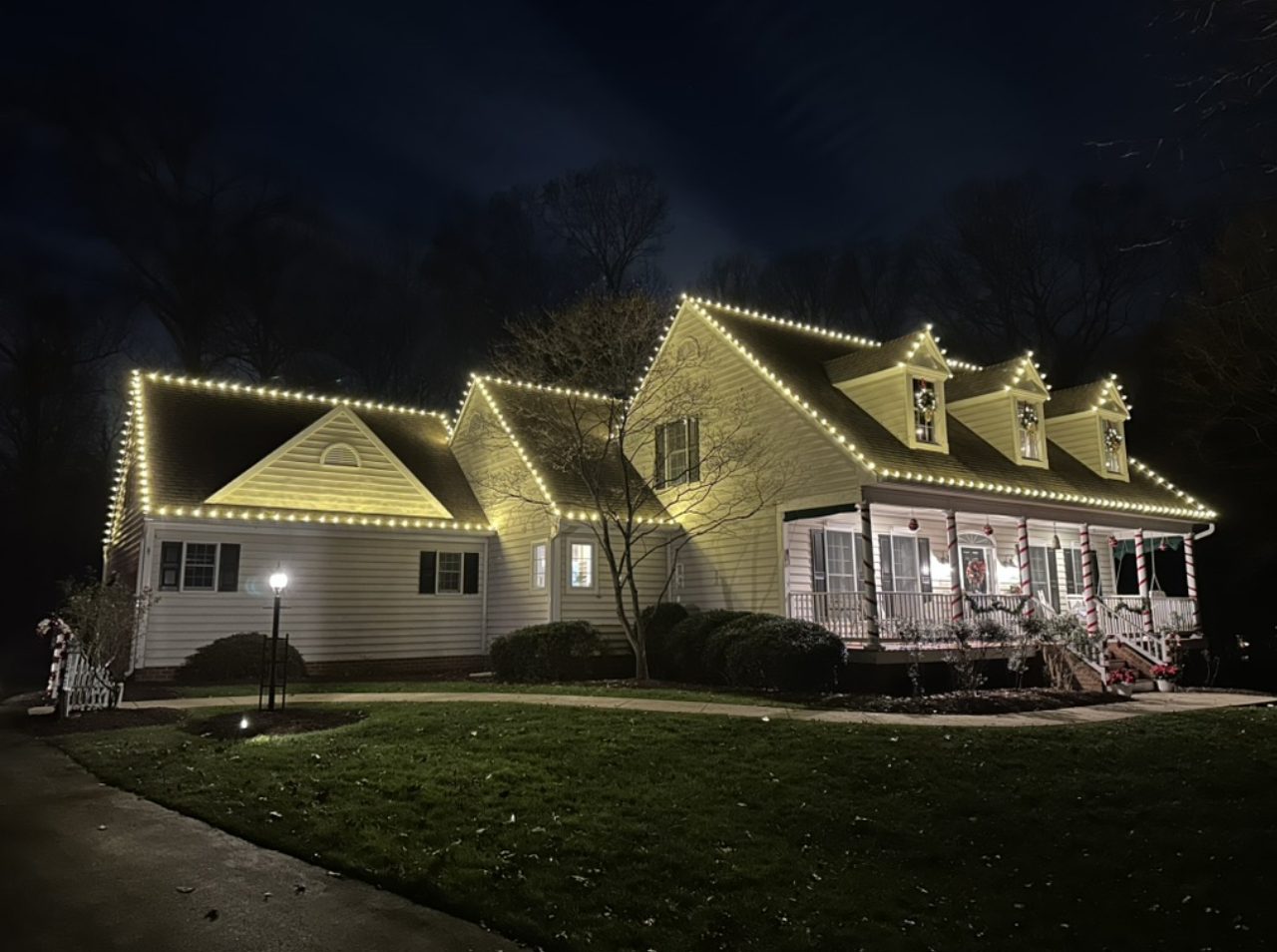 Warm white Christmas roofline lighting on a cape cod home in Maryland
