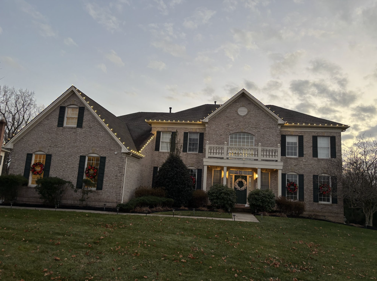 Seasonal lighting installation with roofline and landscape accents