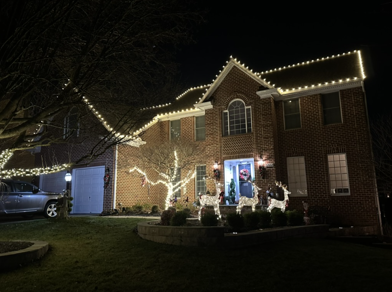 Seasonal roofline lighting on a two-story brick home